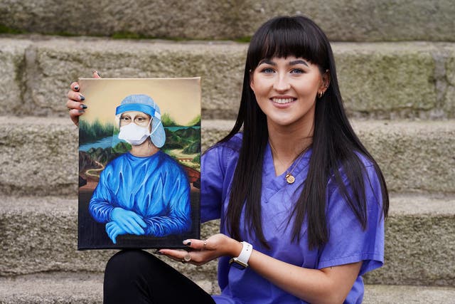 Trainee nurse Chloe Slevin with her painting Corona Lisa, which she is to auction for charity (Brian Lawless/PA)