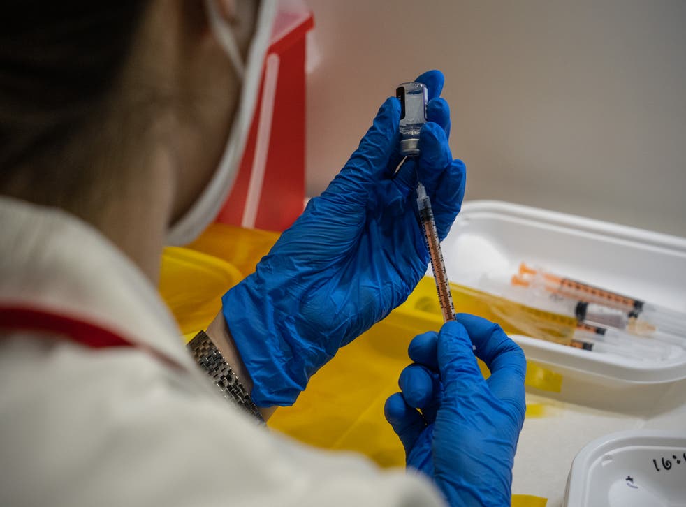 <p>A nurse prepares syringes with the Pfizer coronavirus booster vaccination on 20 January 2022 in Tokyo, Japan</p>