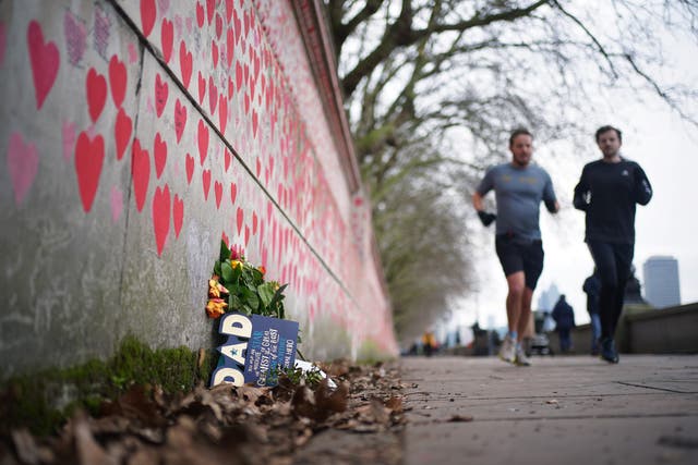 People jogging past the National Covid Memorial Wall (PA)