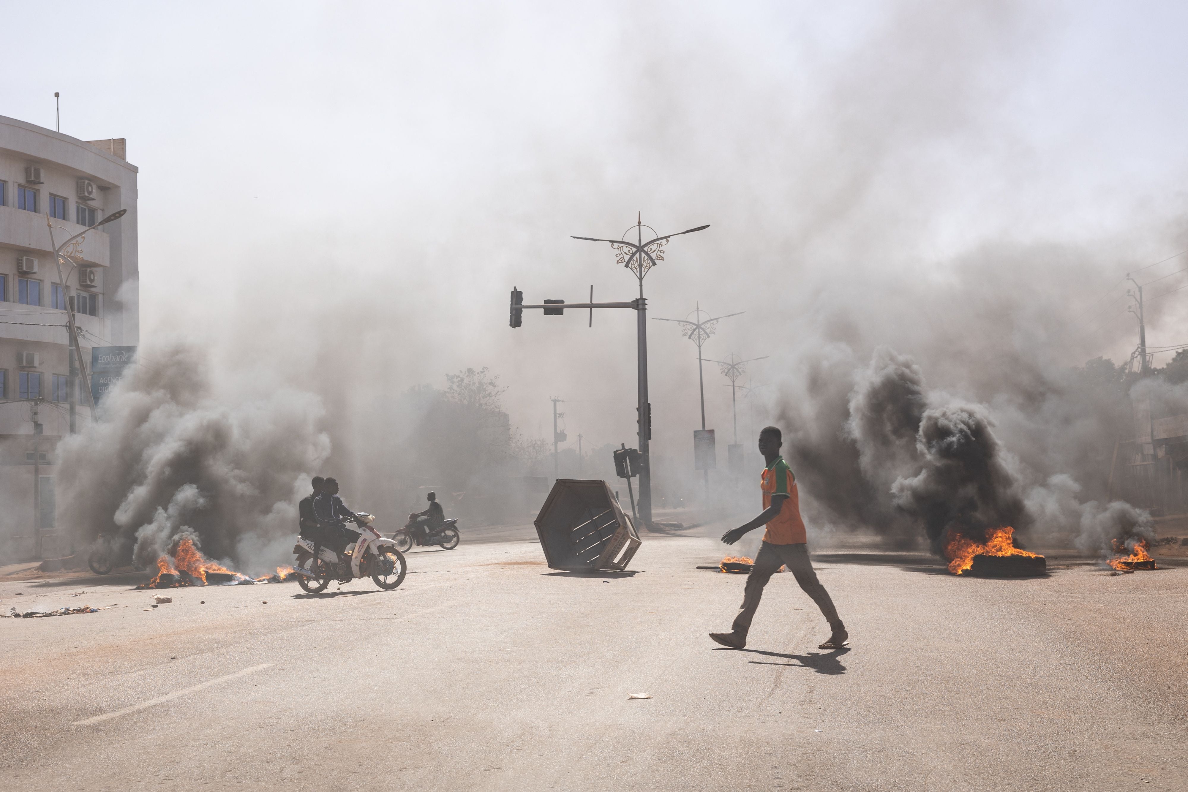 A man crosses through burning barricades in Ouagadougou’s central avenues, where groups of young demonstrators protested against President Roch Marc Christian Kaboré