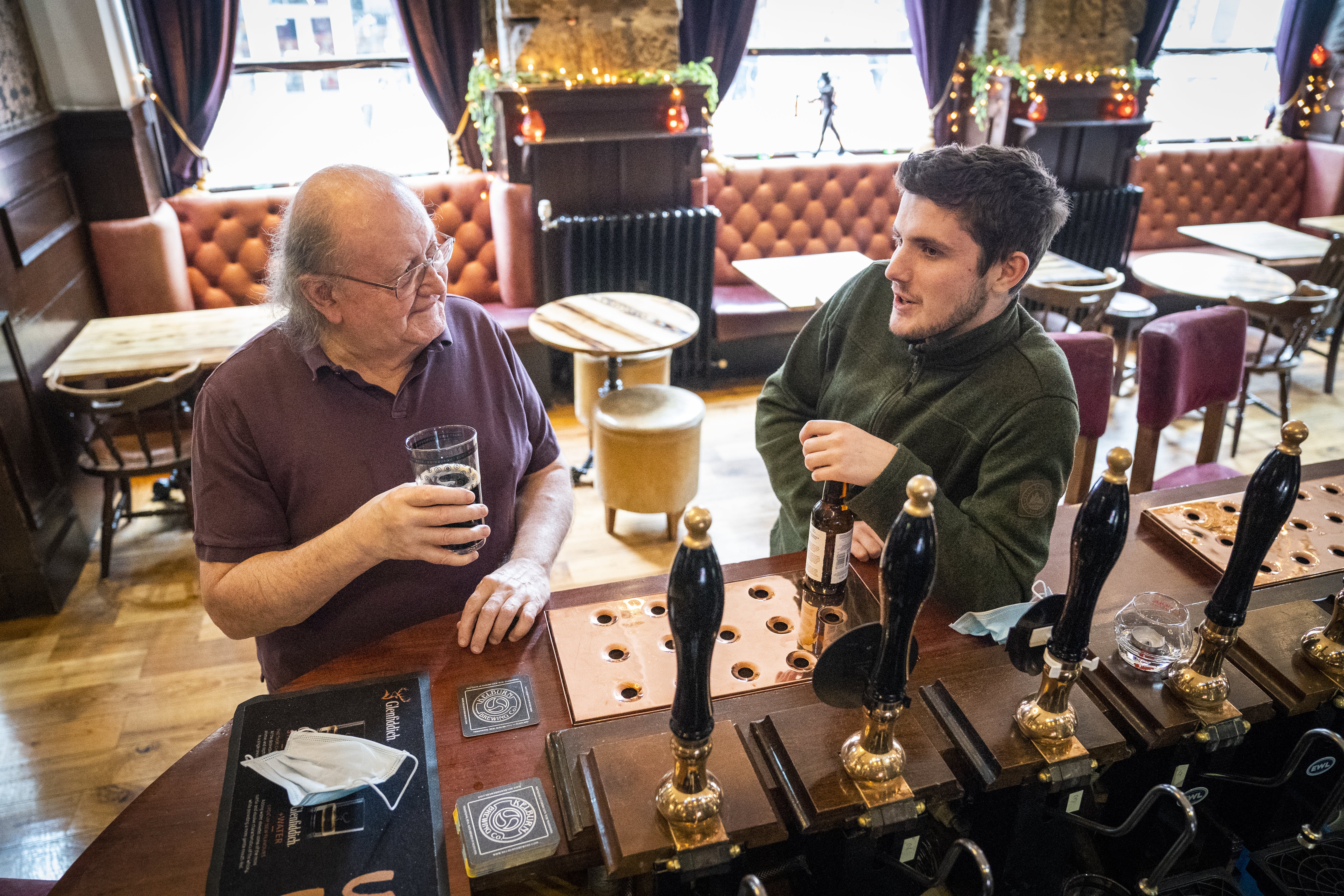 Customers drink at the bar in the No1 High Street pub on Edinburgh’s Royal Mile (Jane Barlow/PA)