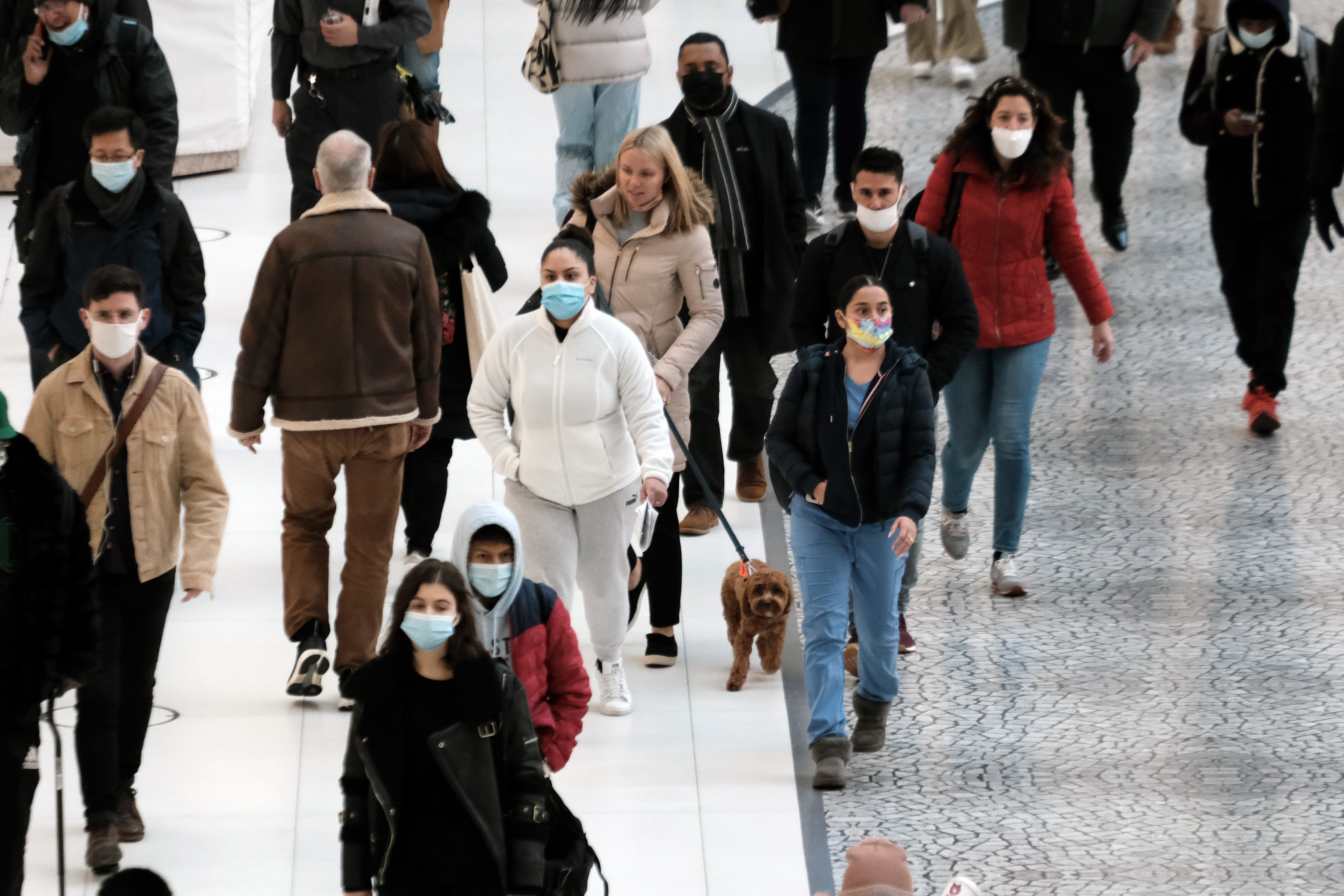 People wear masks at an indoor mall in The Oculus in lower Manhattan on the day that a mask mandate went into effect in New York on 13 December 2021 in New York City