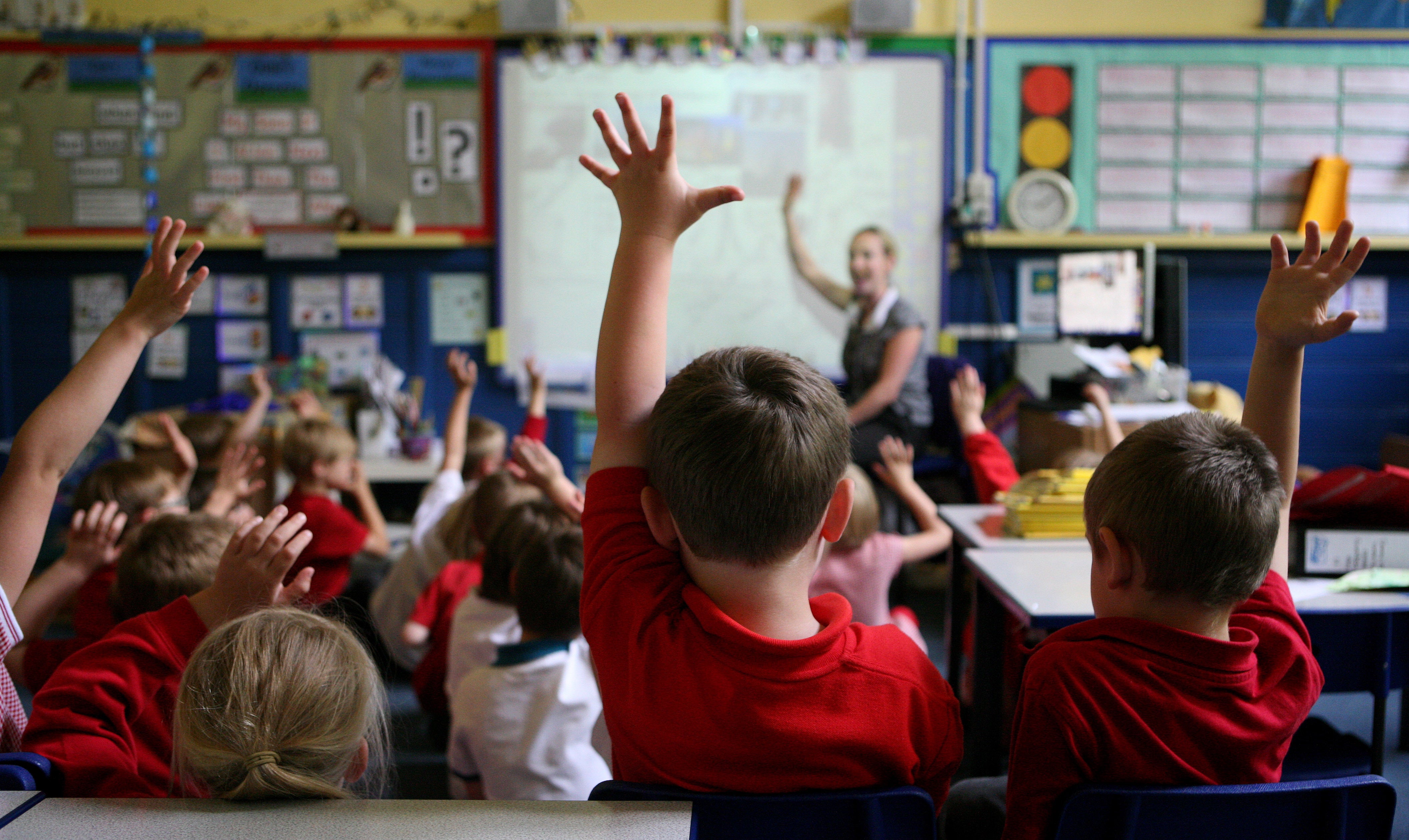 Children raise their hands to answer a question (Dave Thompson/PA)