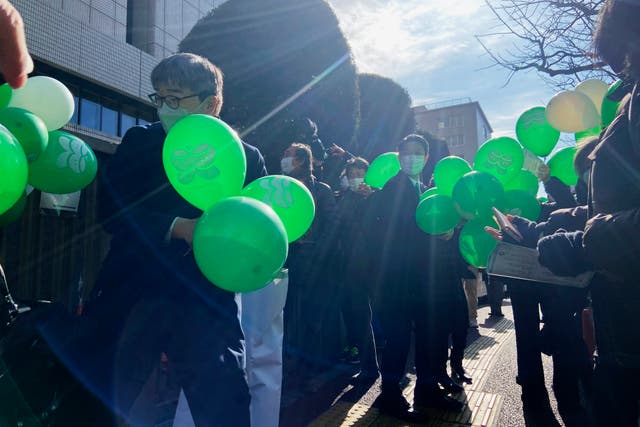 <p>Supporters of six plaintiffs who were children at the time of the 2011 Fukushima nuclear plant disaster stand outside a court in Tokyo on 27 January </p>