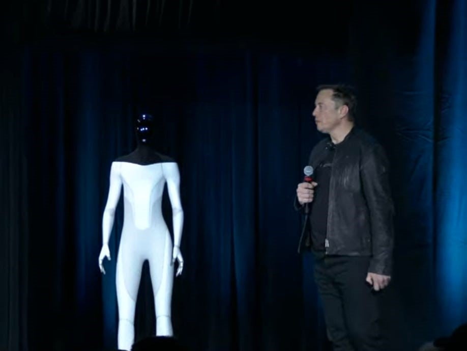 Elon Musk on stage with a mocked-up version of Tesla’s humanoid robot in August 2021