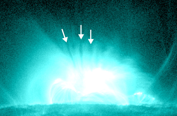 Still image of several supra-arcade downflows, also described as “dark, finger-like features,” occurring in a solar flare