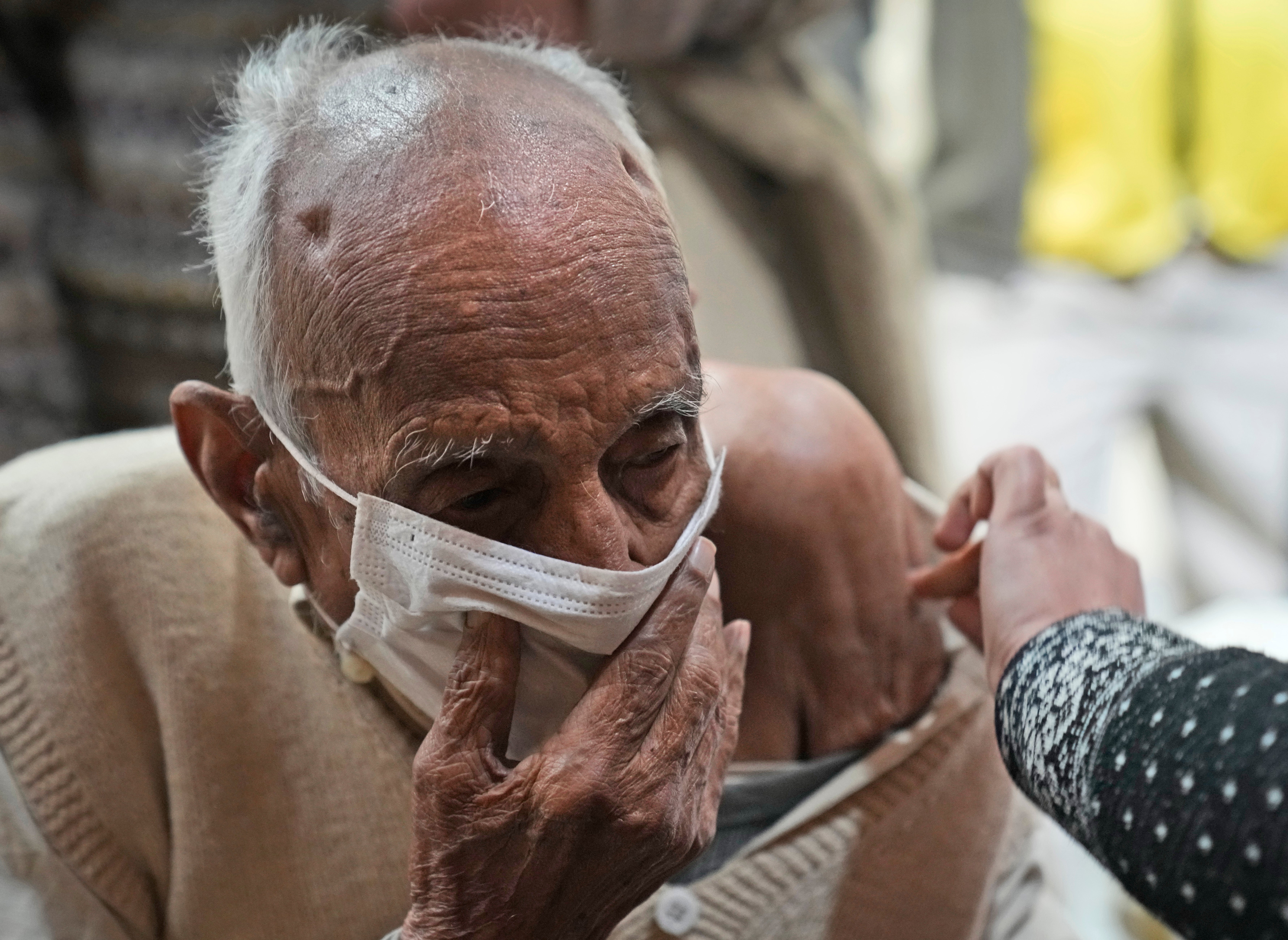 An elderly man receives a Covid vaccination at a makeshift centre in a government school in New Delhi, India on 28 January 2022