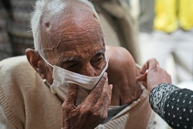 <p>An elderly man receives a Covid vaccination at a makeshift centre in a government school in New Delhi, India on 28 January 2022</p>