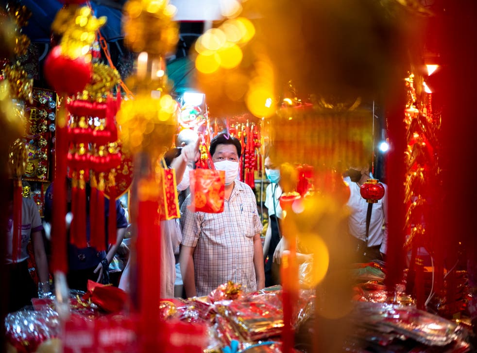 <p>A man wearing a face mask shops ahead of the Chinese Lunar New Year celebrations in Bangkok, Thailand </p>