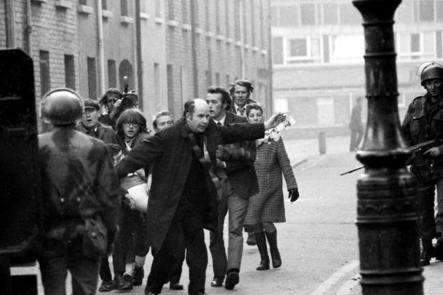 <p>Father Edward Daly, later Bishop of Derry, waves a blood-stained white handkerchief at soldiers as a mortally wounded protester is carried away, on 30 January 1972 </p>