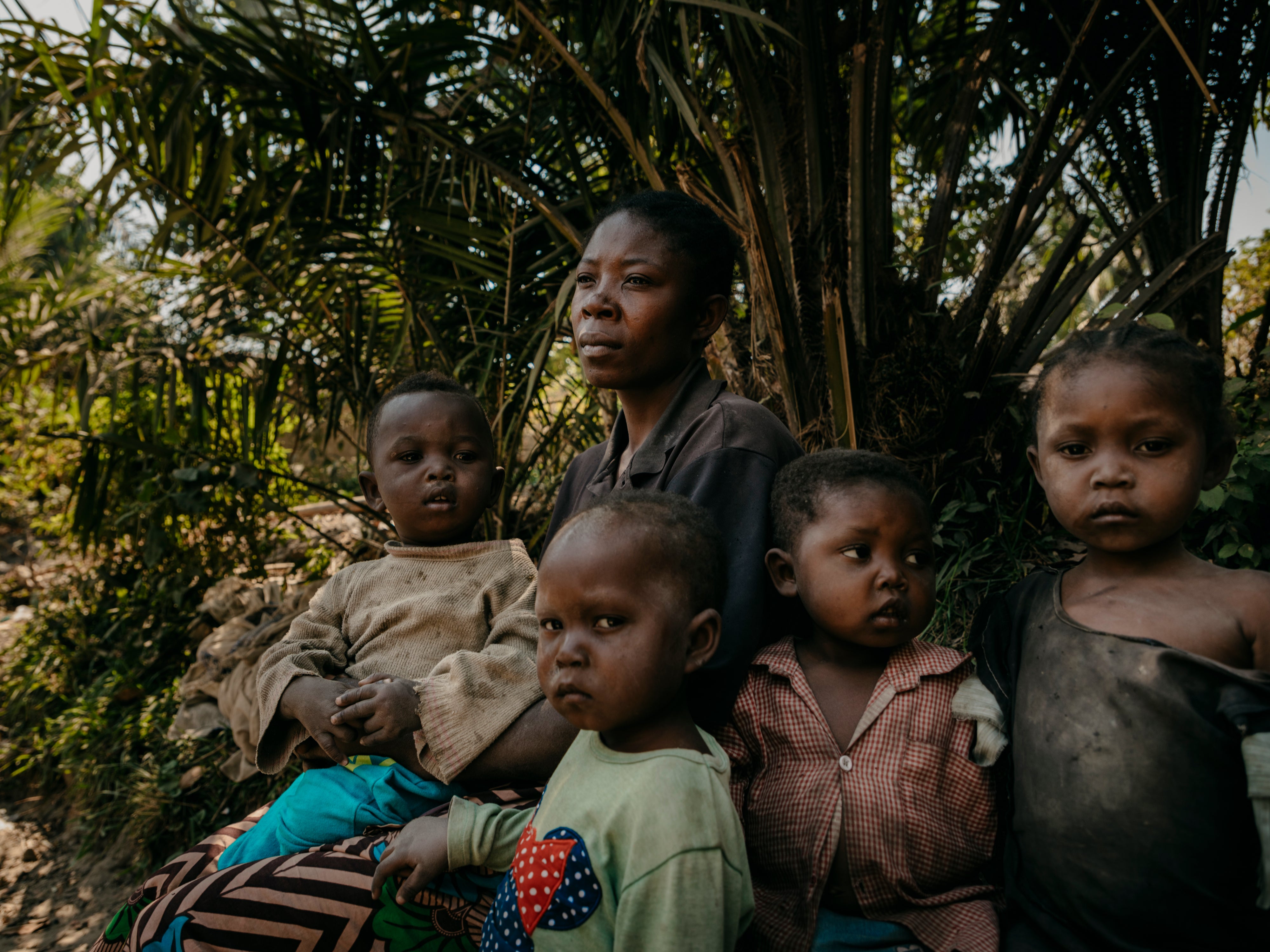 Marie*, 36, poses for a portrait with her children Freddy*, 1, Joseph*, 2, Claris*, 3, and Micheline*, 4, in Lomami province