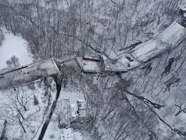 <p>Aerial photo shows a Port Authority bus that was on a bridge when it collapsed Friday Jan. 28, 2022, is visible through trees in Pittsburgh's East End</p>