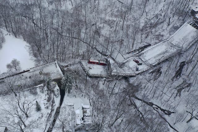 <p>Aerial photo shows a Port Authority bus that was on a bridge when it collapsed Friday Jan. 28, 2022, is visible through trees in Pittsburgh's East End</p>