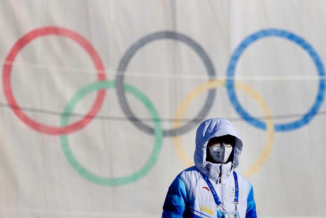 <p>A volunteer stands next to the aerials course during preparations for the Beijing 2022 Winter Olympics, in Zhangjakou</p>