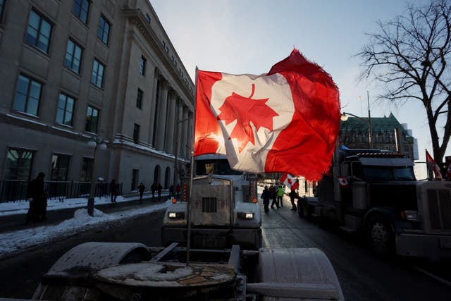 <p>A Canadian flag flies upside down on the back of a truck during a "Freedom Convoy" protesting against COVID-19 vaccine mandates and restrictions in front of the Parliament of Canada on January 28, 2022 in Ottawa, Canada. </p>