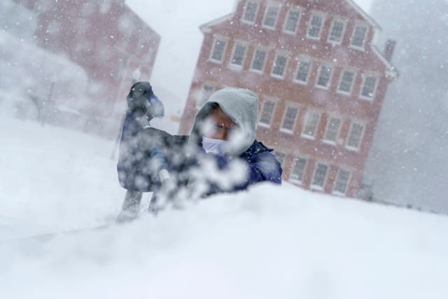 <p>Xavier Martínez raspa la nieve de su parabrisas durante una tormenta en Providence, RI, el 29 de enero de 2022</p>