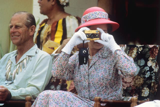 <p>The Queen taking photographs on Tuvalu in 1982 (Ron Bell/PA)</p>