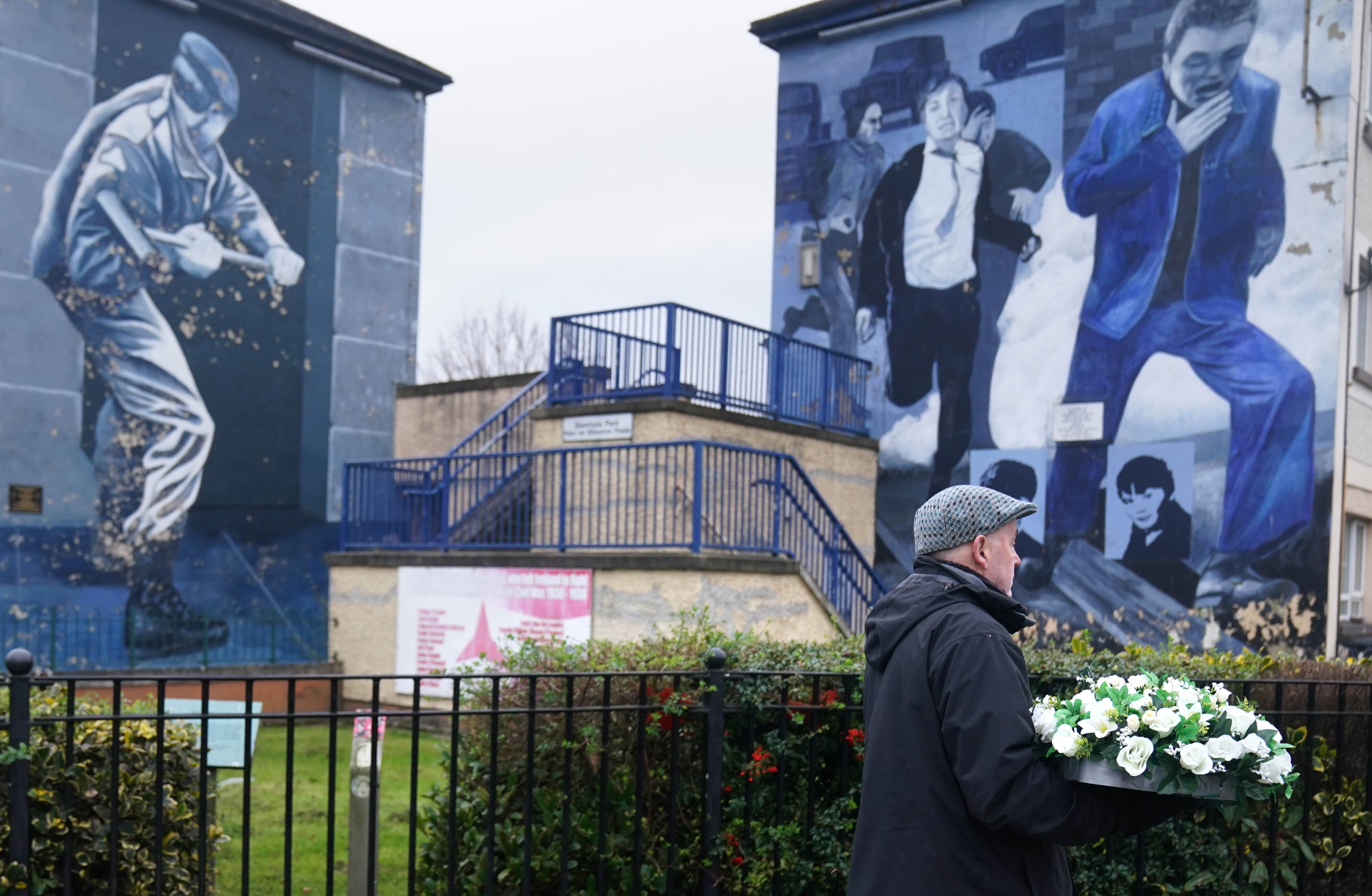 A man with flowers at the Bloody Sunday memorial in Derry (Brian Lawless/PA)