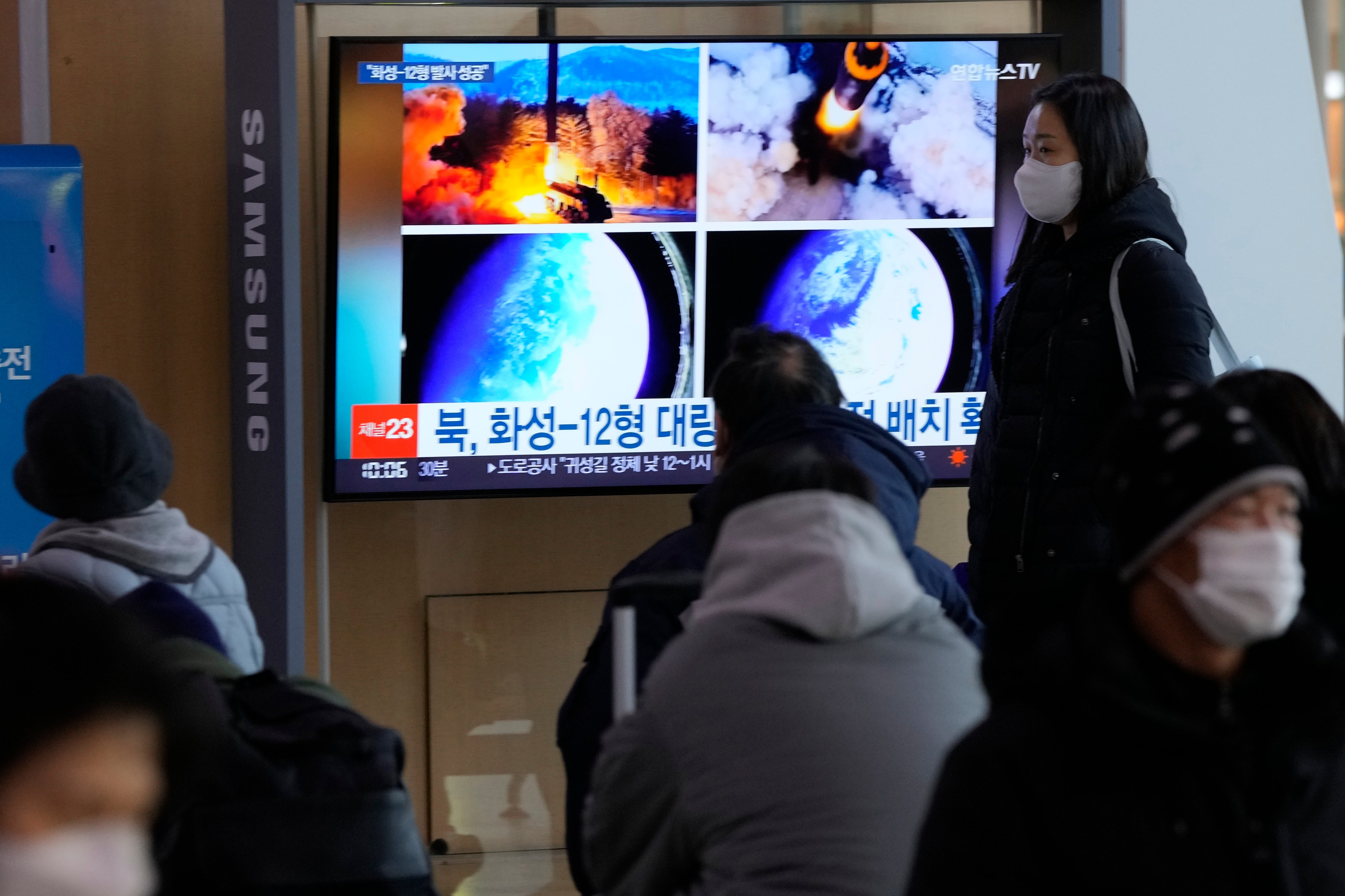 People watch a TV showing images of North Korea's missile launch during a news program at the Seoul Railway Station