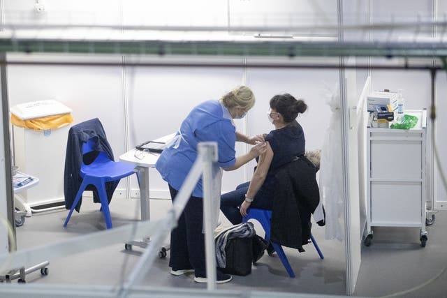 A nurse administers a coronavirus vaccine to a health and care staff member (PA)