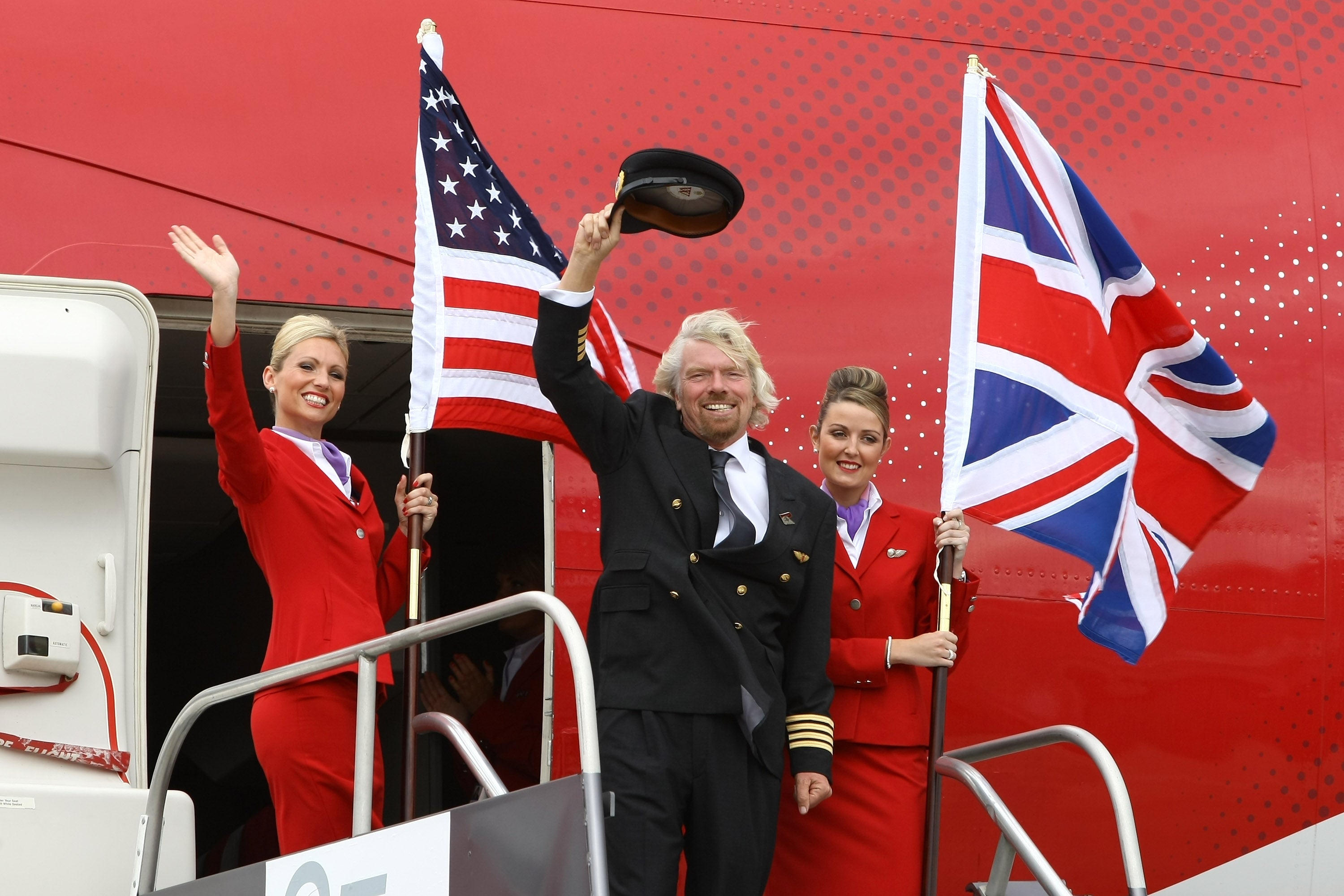<p>Virgin Atlantic boss Richard Branson flanked by two crew members in June 2009</p>
