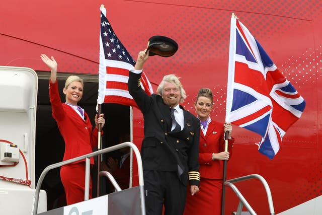 <p>Virgin Atlantic boss Richard Branson flanked by two crew members in June 2009</p>