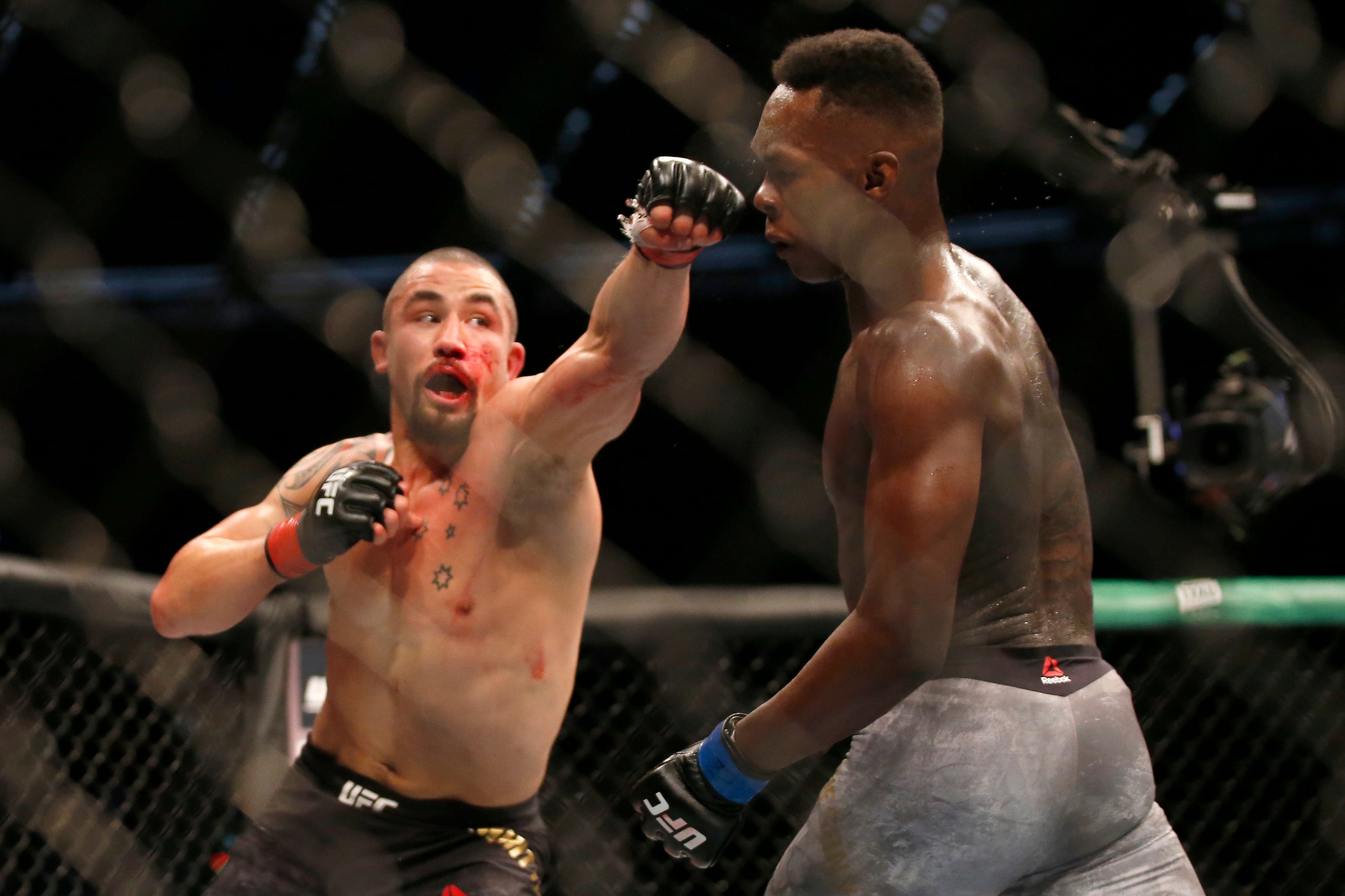 Israel Adesanya (right) evades a punch from Robert Whittaker at UFC 243