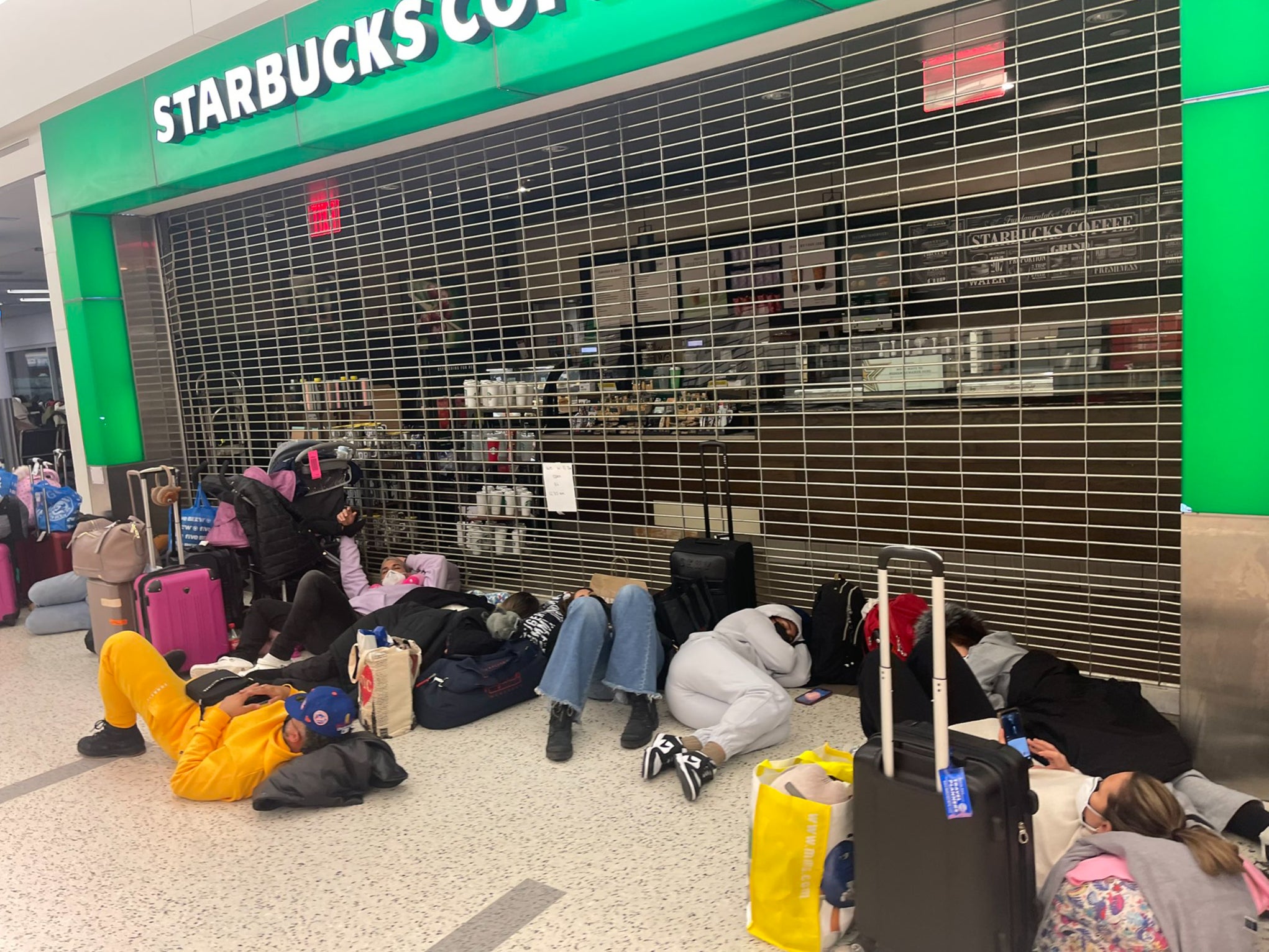 Jet Blue passengers sleep on the floor outside a Starbucks in JFK International Airport after delays left planes stranded on the tarmac for hours.