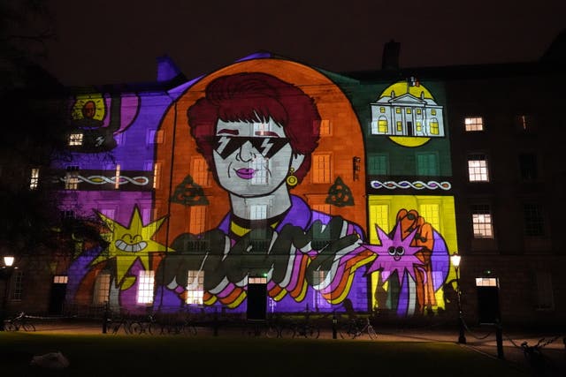 Crowds look at a projections on the walls of Trinity College Dublin to mark St Brigid’s Day (Niall Carson/PA)