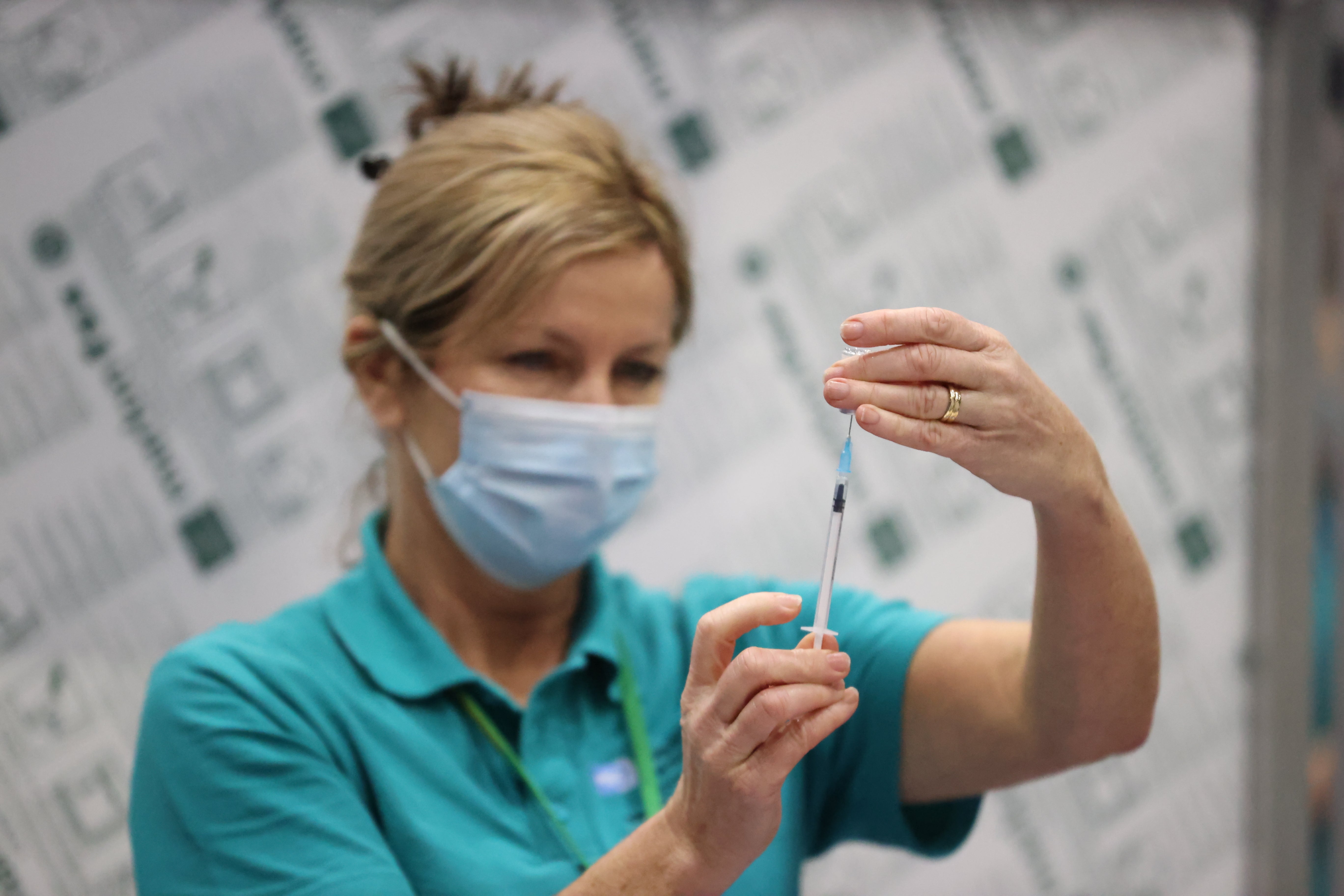 A vaccinator prepares vaccines at a Covid-19 booster vaccination centre (Liam McBurney/PA)