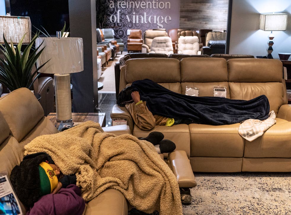 <p>People sleep on couches while taking shelter at Gallery Furniture store which opened its door and transformed into a warming station after winter weather caused electricity blackouts on 18 February 2021 in Houston, Texas</p>