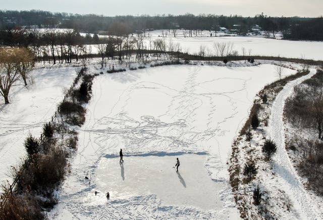 <p>Two men practicing their hockey skills on a frozen pond in Round Lake Heights, Illinois on Sunday. More snow and ice is on the way for the Midwest</p>