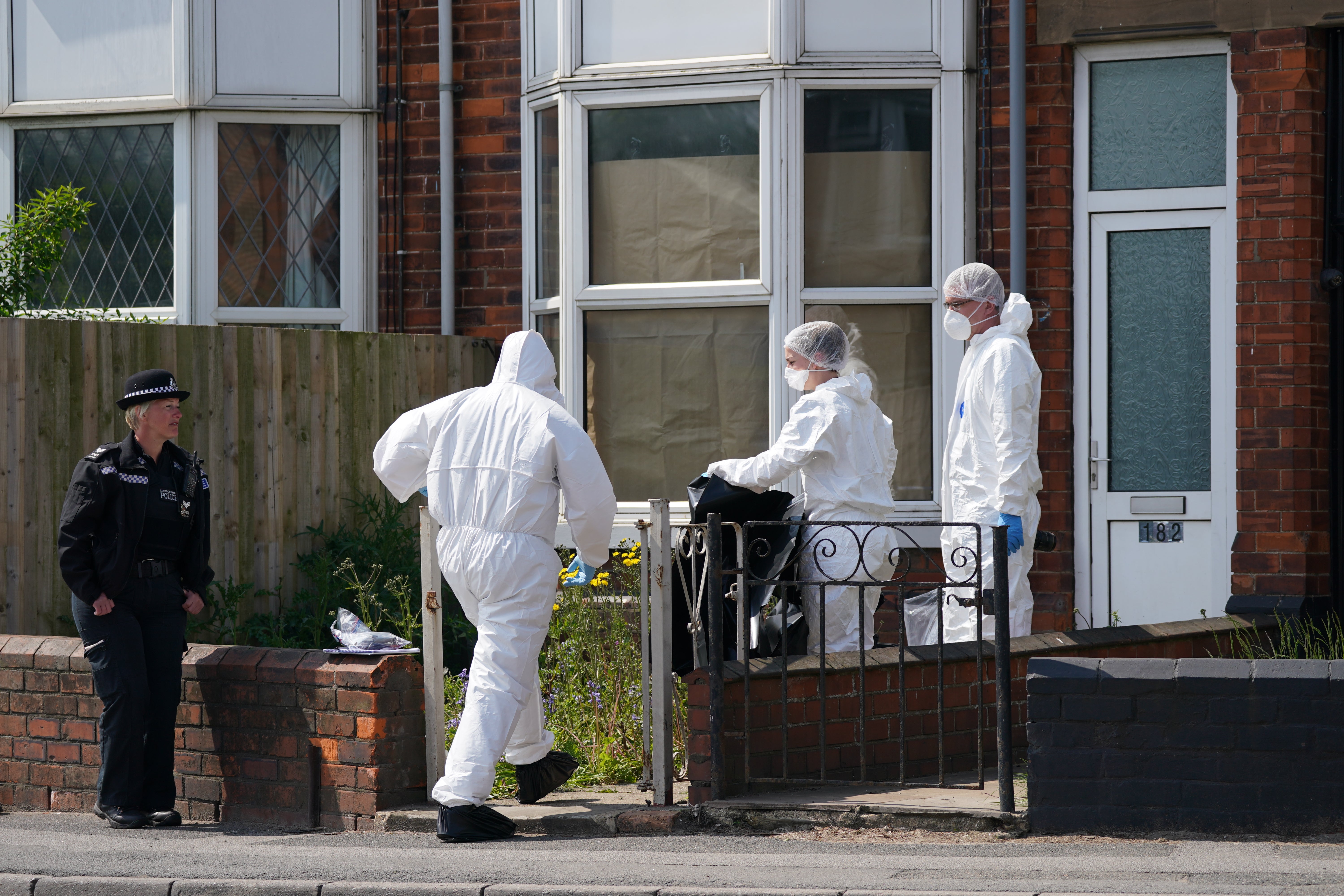 Police officers at the scene in High Holme Road, Louth, the day after the murders (Joe Giddens/PA)