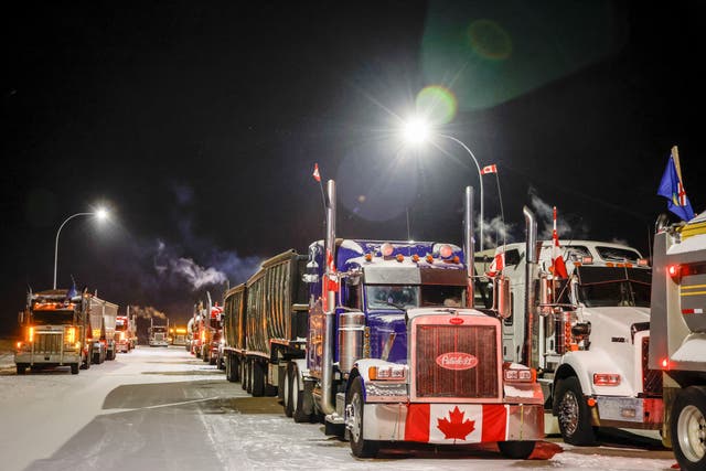 <p>A truck convoy blocks the highway at the US border crossing as demonstrators protesting against Covid-19 vaccine mandates gather in Coutts, Alberta</p>