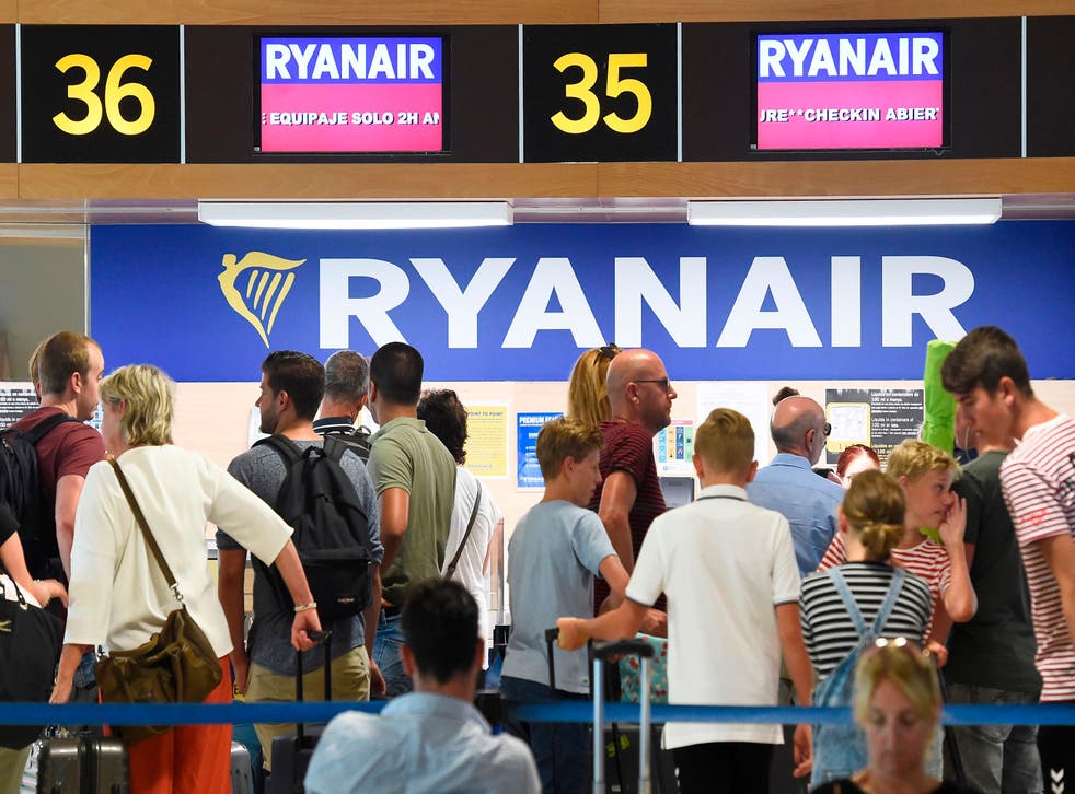 <p>Passengers queue at a Ryanair check-in counter in Valencia</p>