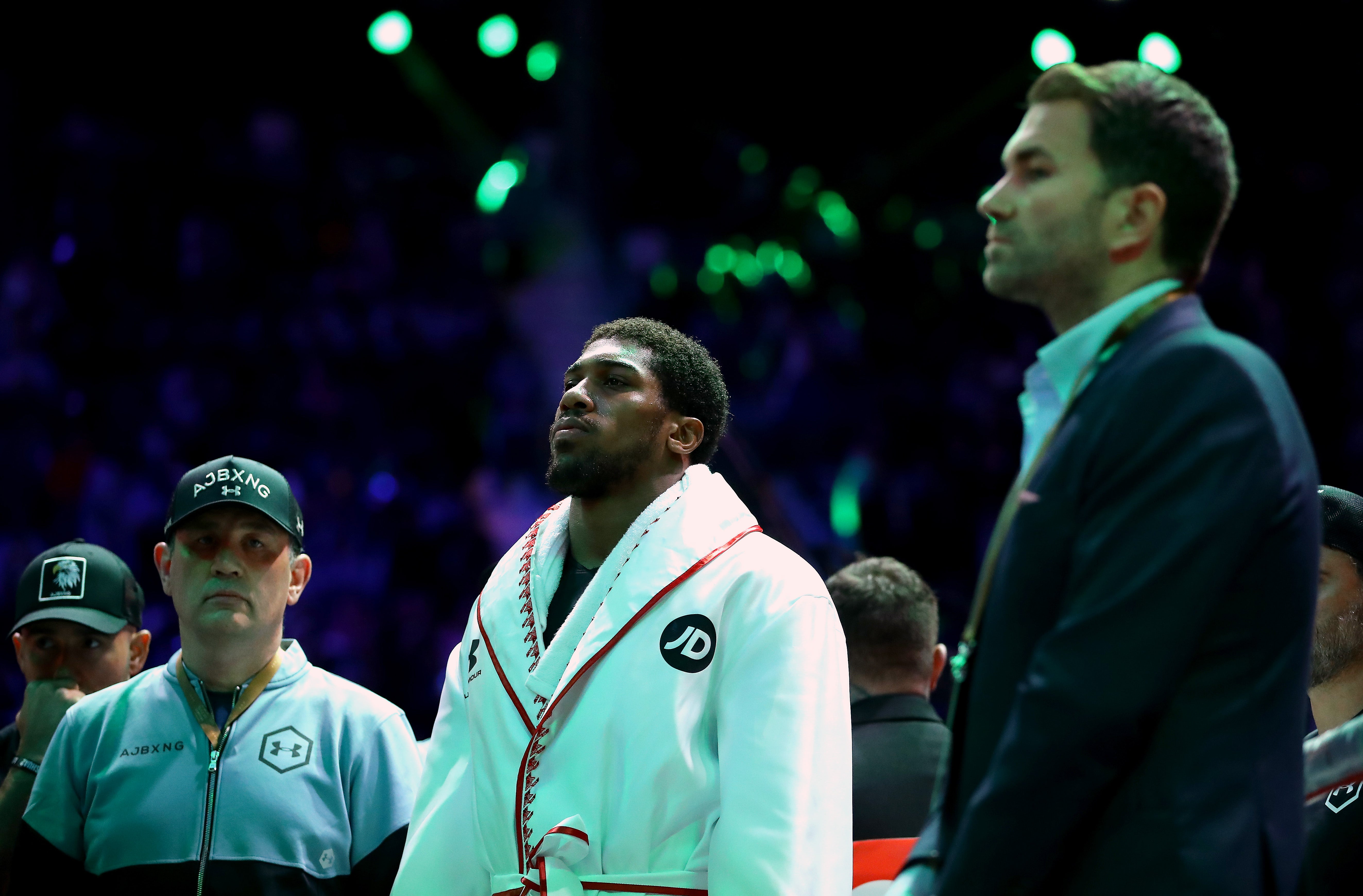 Anthony Joshua between trainer Robert McCracken and promoter Eddie Hearn