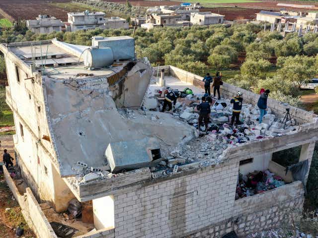 <p>People inspect a destroyed house following an operation by the U.S. military in the Syrian village of Atmeh, in Idlib province, Syria, Thursday, Feb. 3, 2022</p>