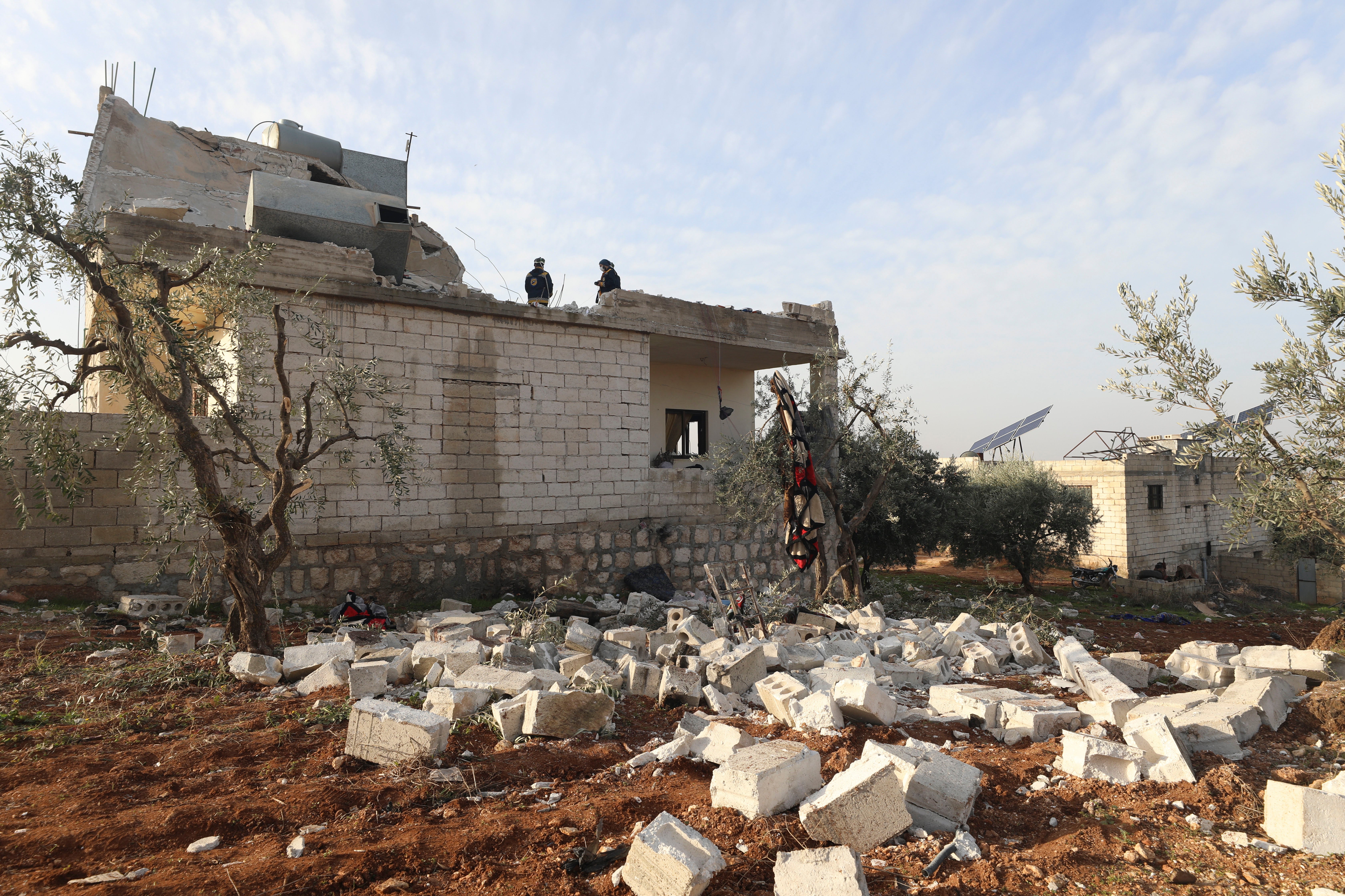 People check at a destroyed house after an operation by the U.S. military in the Syrian village of Atmeh, in Idlib province, Syria, Thursday, Feb. 3, 2022
