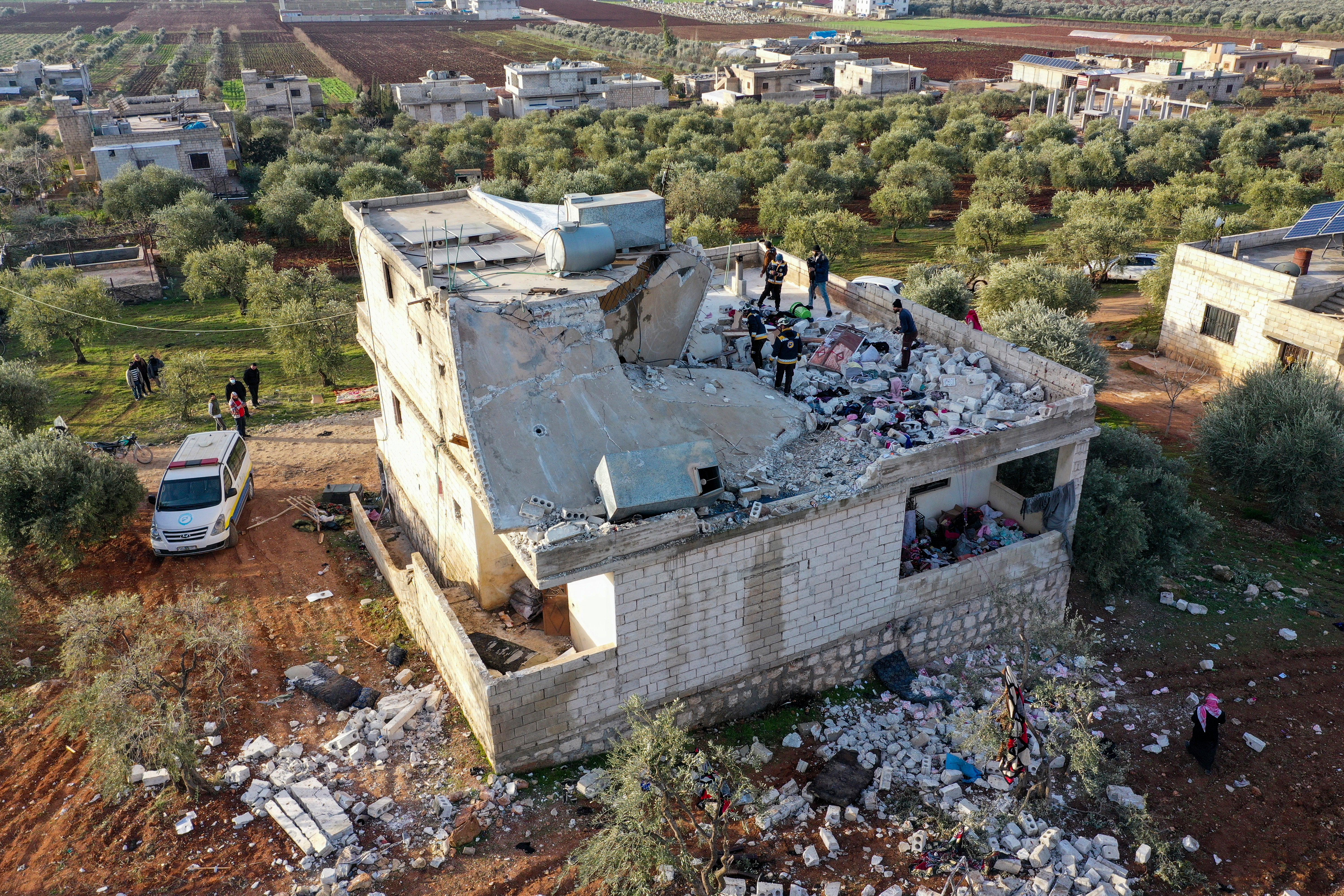 People inspect a destroyed house following an operation by the U.S. military in the Syrian village of Atmeh, in Idlib province, Syria, Thursday, Feb. 3, 2022