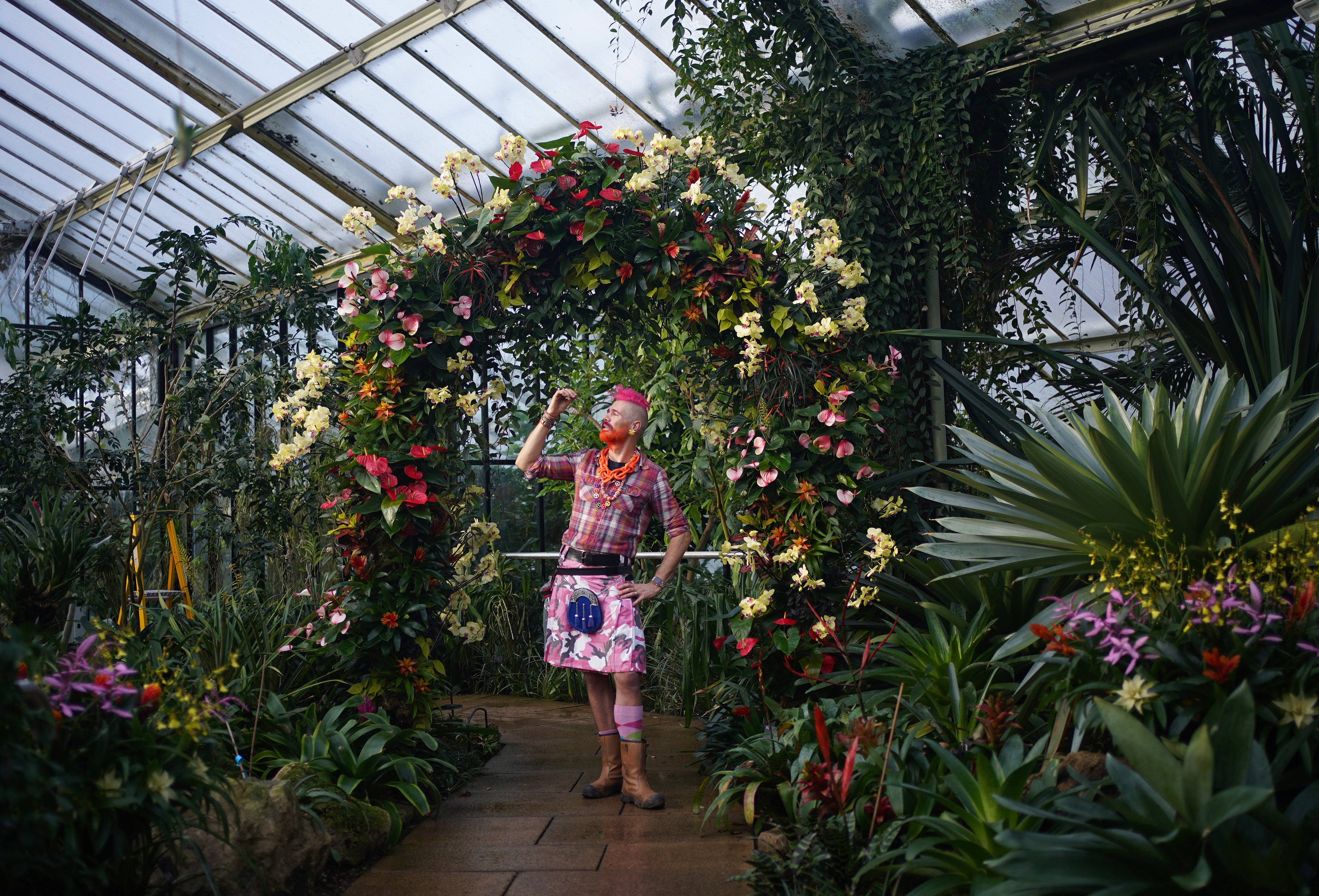 Henck Roling, in-house florist at Kew, poses with a display at the Kew Orchid Festival (Yui Mok/PA)