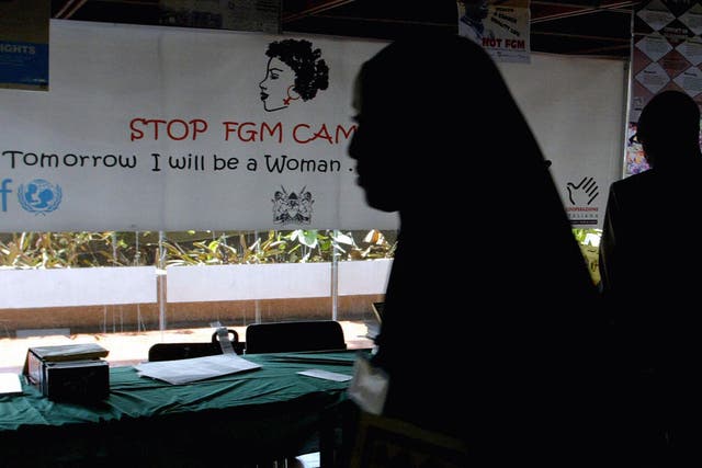 <p>Woman walks past banner against female genital mutilation in Nairobi</p>