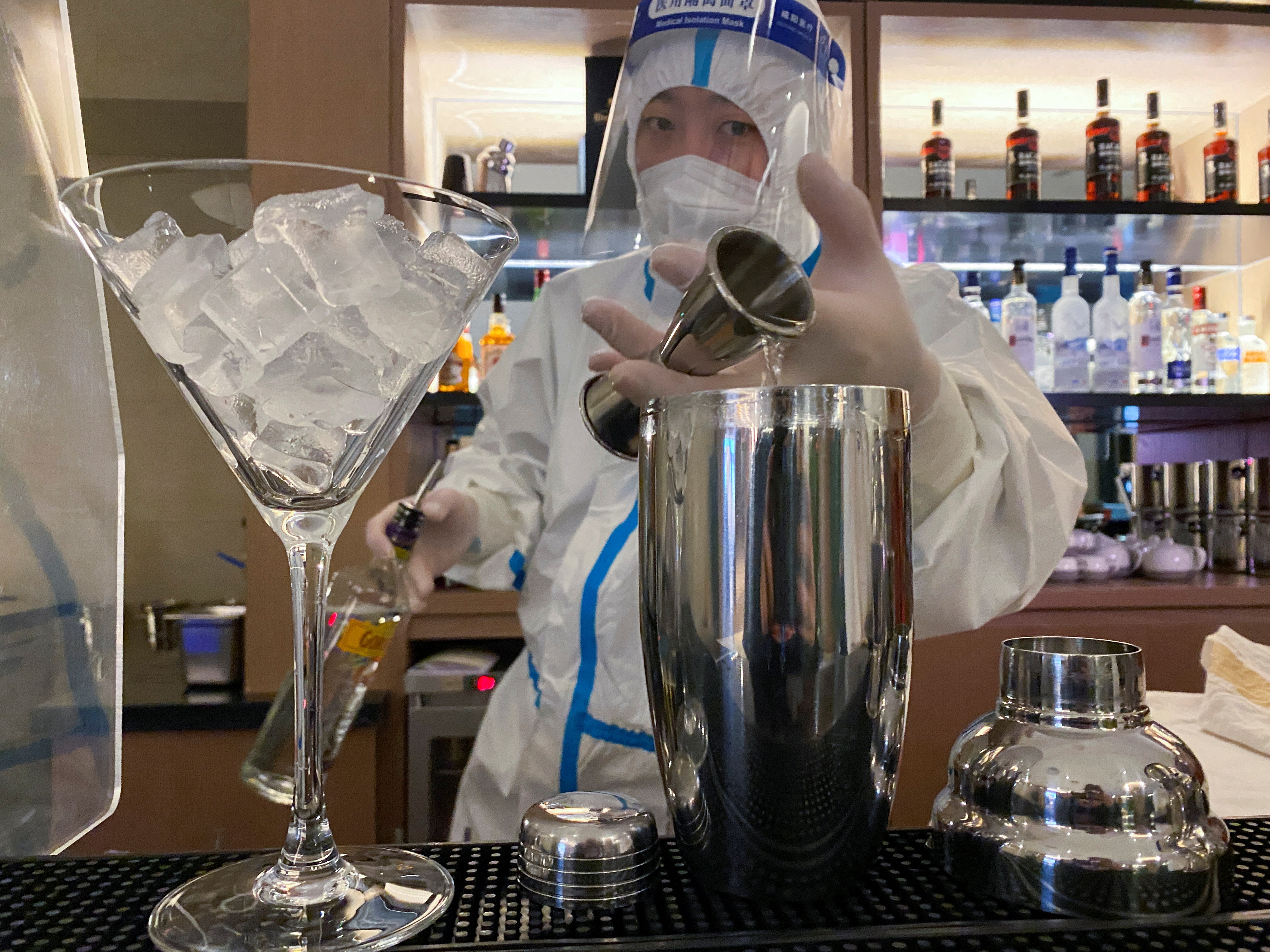A bartender in personal protective equipment (PPE) prepares a cocktail in a hotel for journalists and officials of the Beijing 2022 Winter Olympics, in Zhangjiakou, China