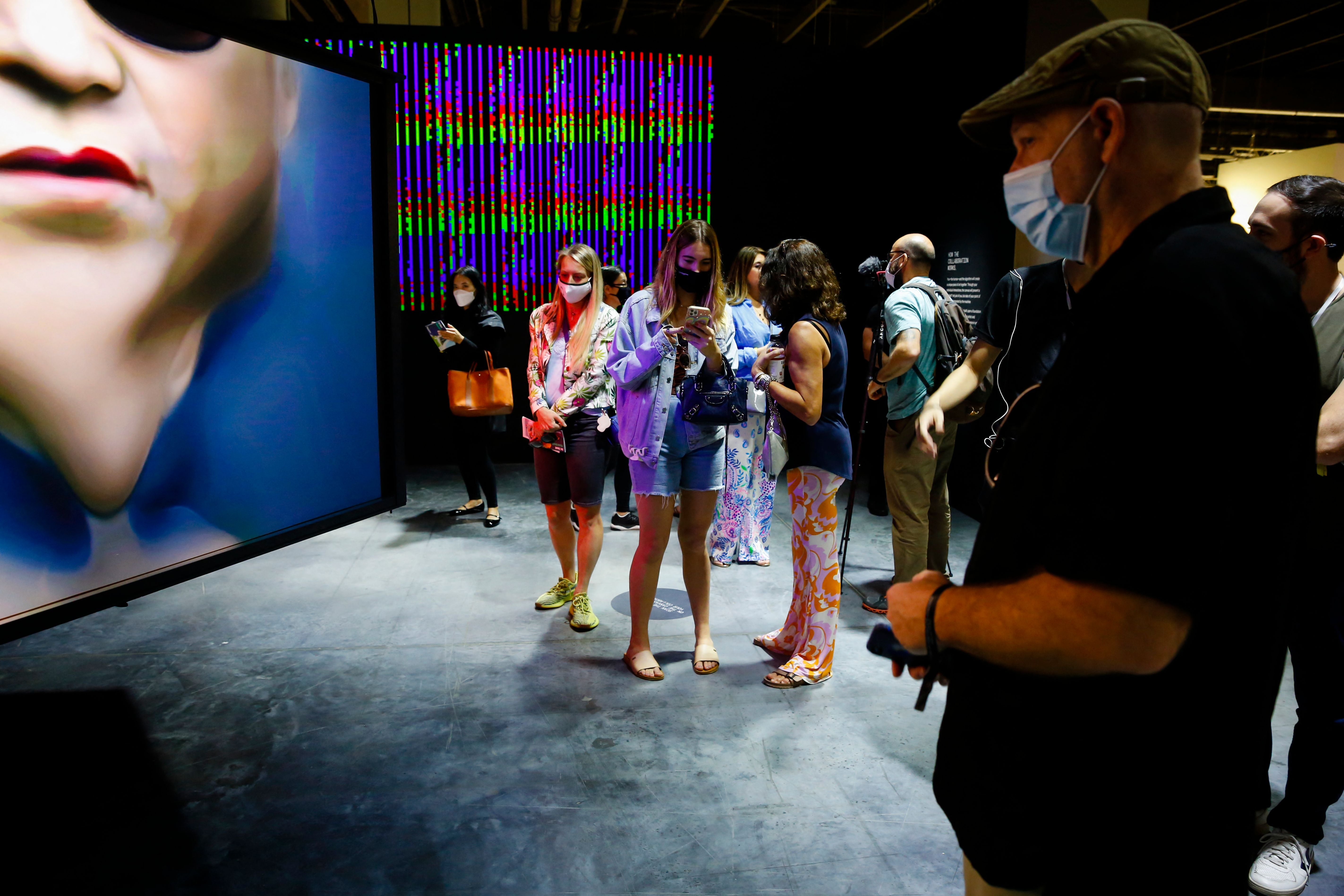 People interact with an NFT artwork by German artist Mario Klingeman during Art Basel 2021 at Miami Beach Convention Center in Miami Beach, Florida on December 2, 2021.