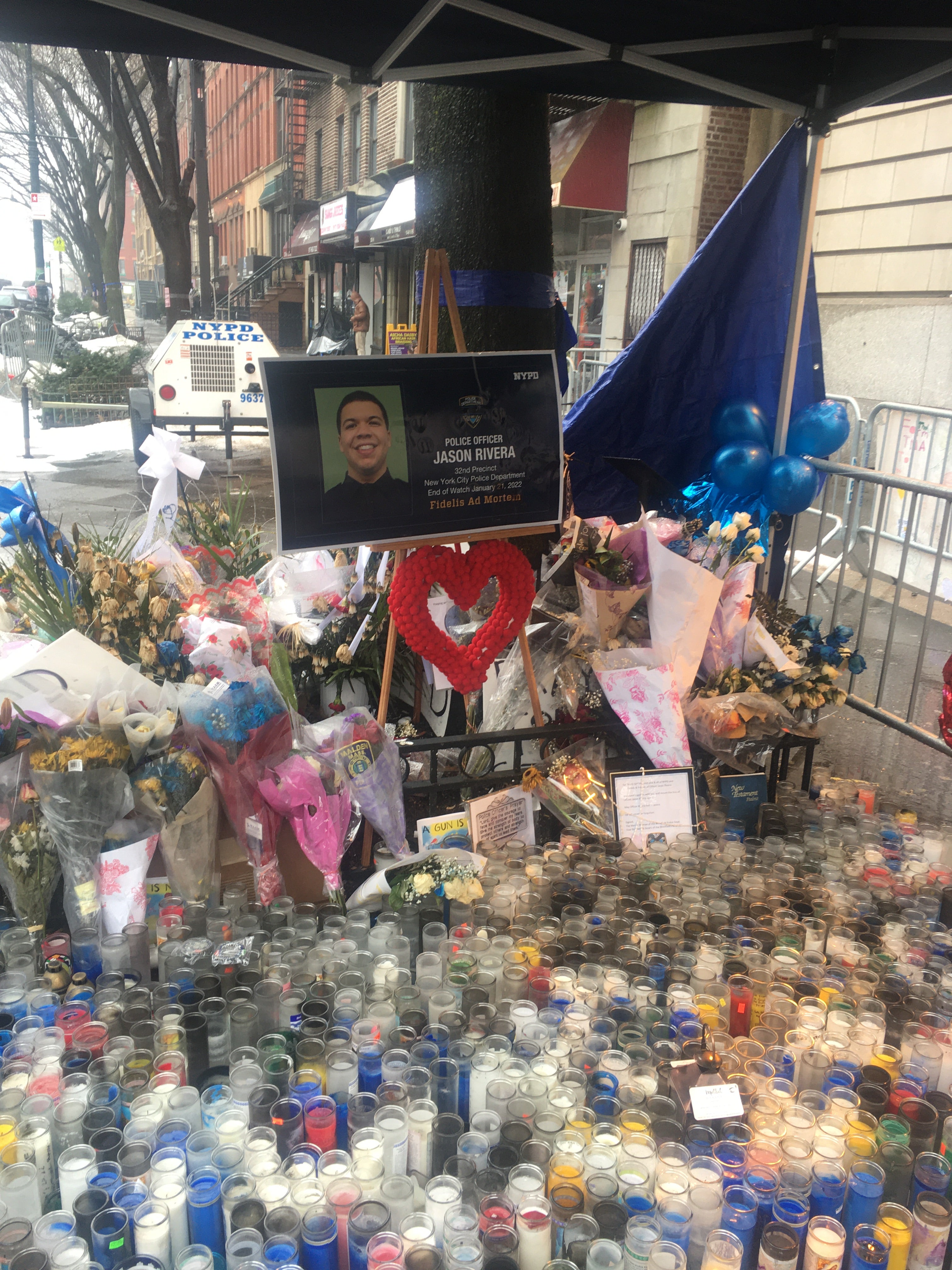 A tribute to NYPD officer Jason Rivera outside the 135th St police precinct in Harlem