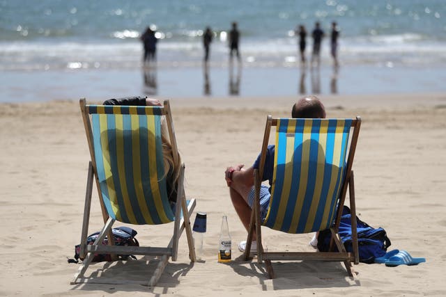 <p>People enjoy the sun on a British beach </p>