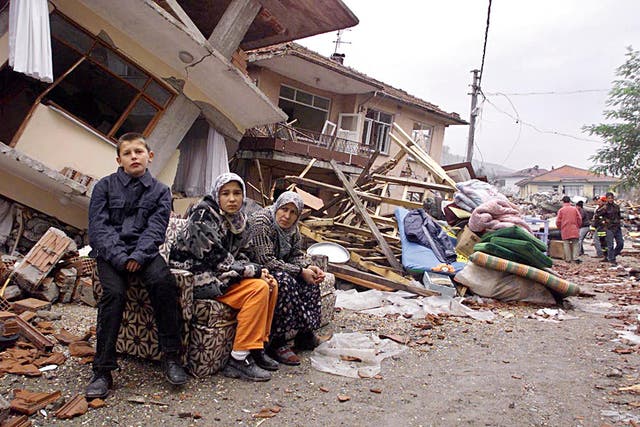 <p>A Kaynasli family sit on what is left of their possessions after the earthquakes </p>