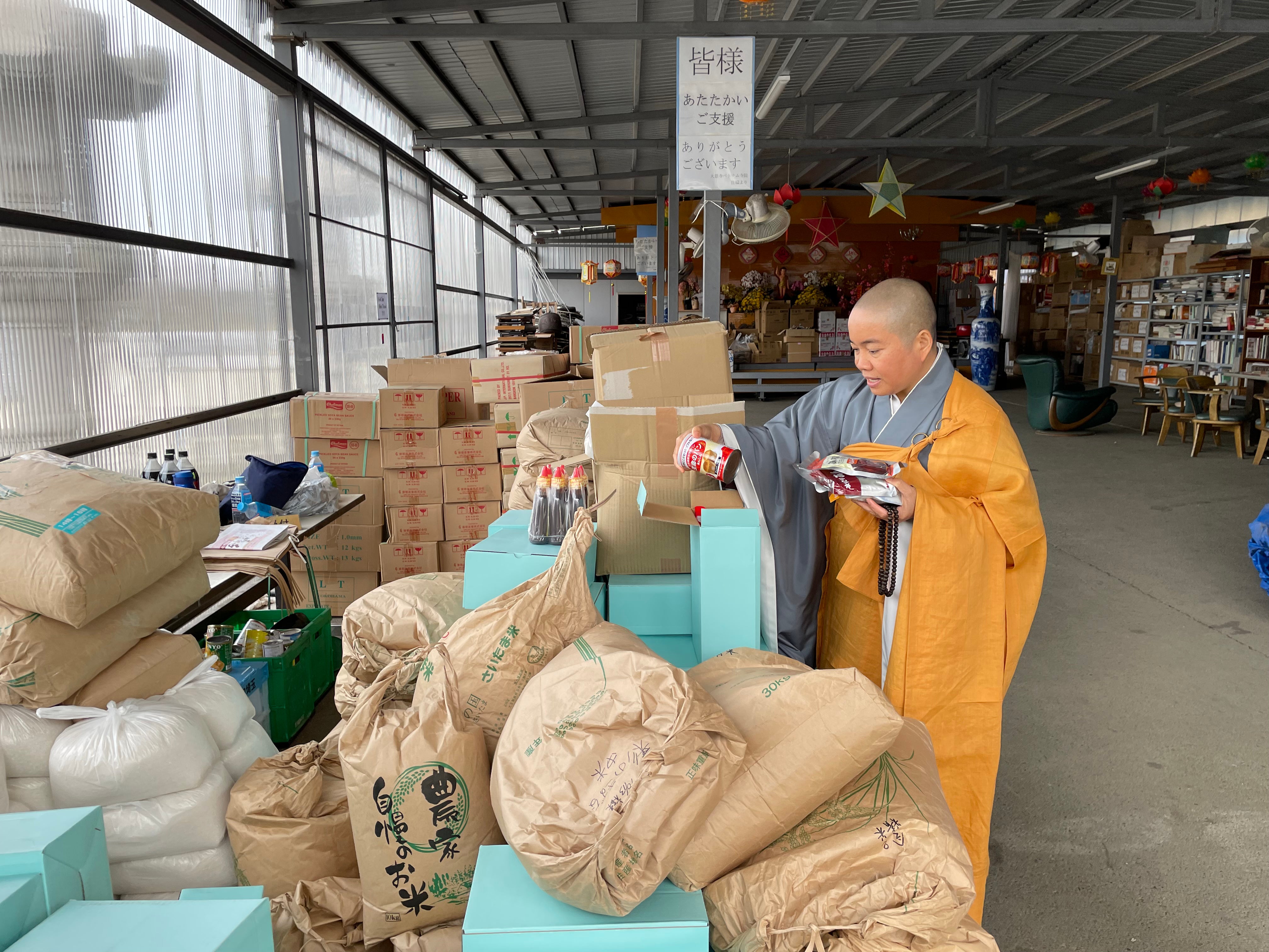 Thich Tam Tri sorts through boxes collected at her temple for Vietnamese migrants who are in need of food and supplies.