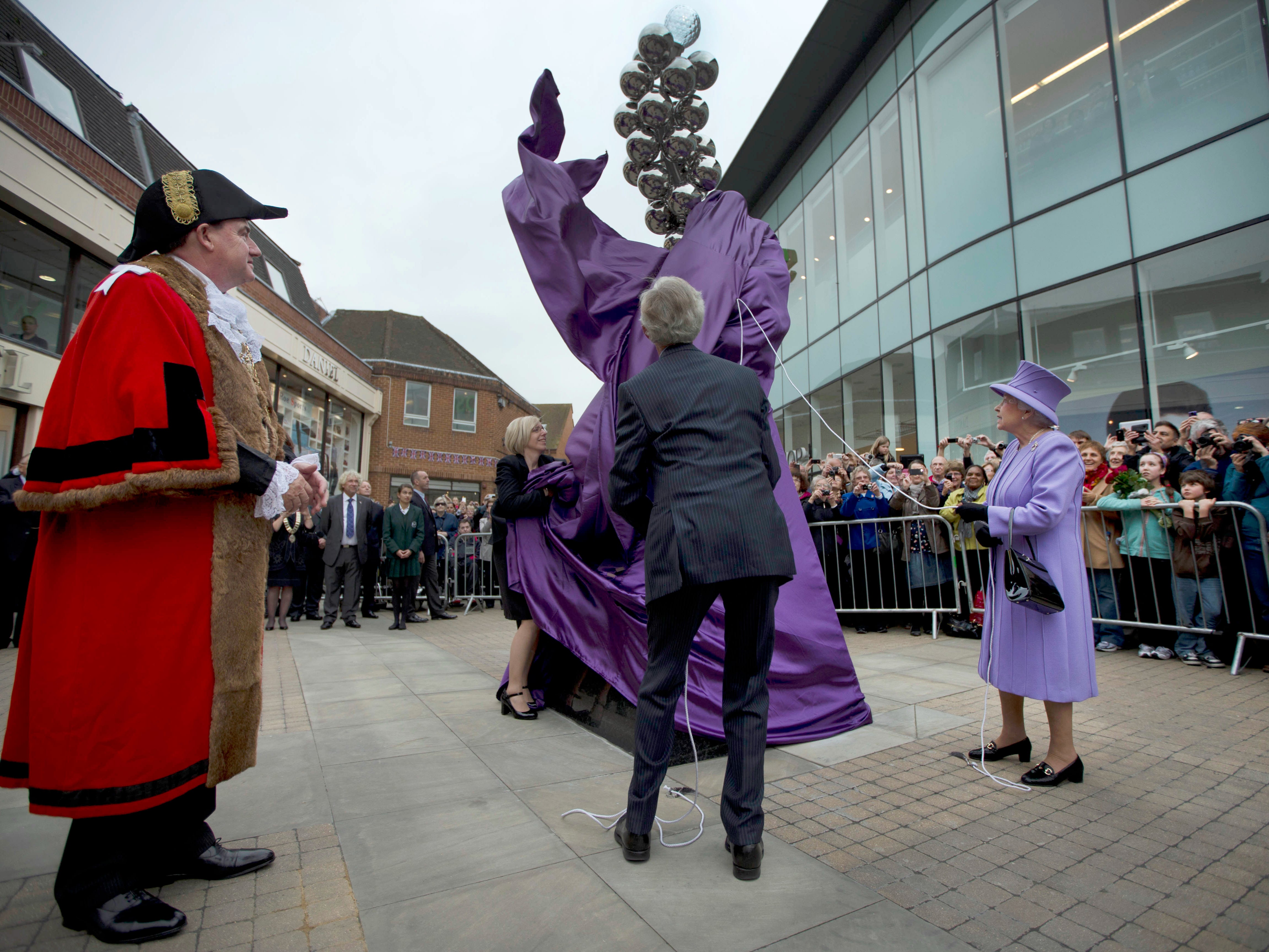 Britain's Queen Elizabeth II unveils a Diamond Jubilee monument to mark her 60 years on the throne, watched by the local mayor Colin Rayner