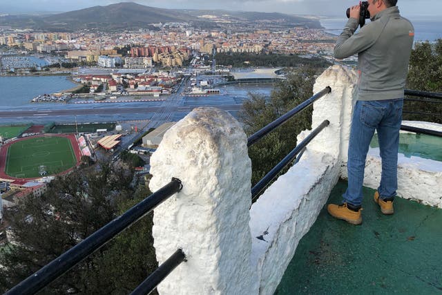<p>Multinational view: photographer on an outcrop of the Rock of Gibraltar, overlooking the airport runway and southern Spain</p>