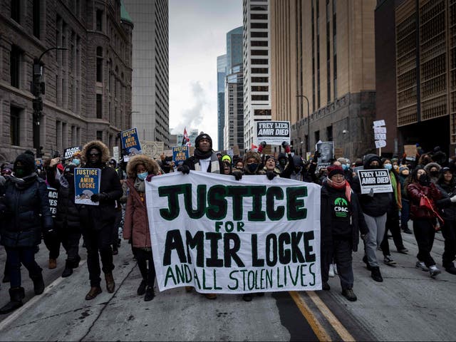 <p>Demonstrators march behind a banner reading “Justice for Amir Locke and All Stolen Lives” during a rally in protest of the killing of Amir Locke, outside the Hennepin County Government Center in Minneapolis, Minnesota on February 5, 2022</p>